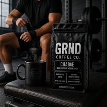 GRND Coffee CHARGE bag and steaming mug on a training bench with athlete preparing to work out